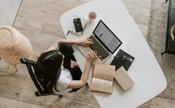 student-with-laptop-and-book-on-table